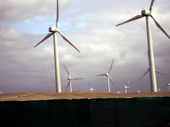 Wind turbines in Gran Canaria. Under their base, agricultural greenhouses